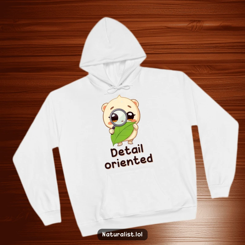 Funny hoodie with a round creature using a magnifying glass on a leaf, emphasizing a humorous and studious personality, a great funny gift.